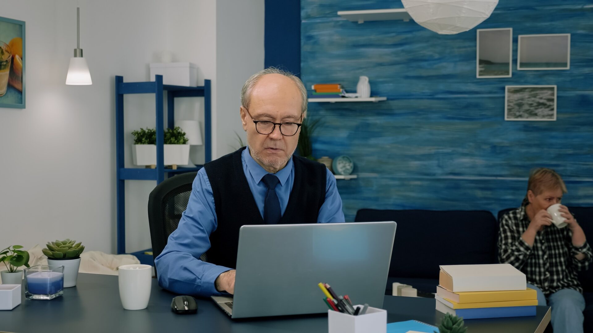 Retired project manager working from home, opening laptop reading news